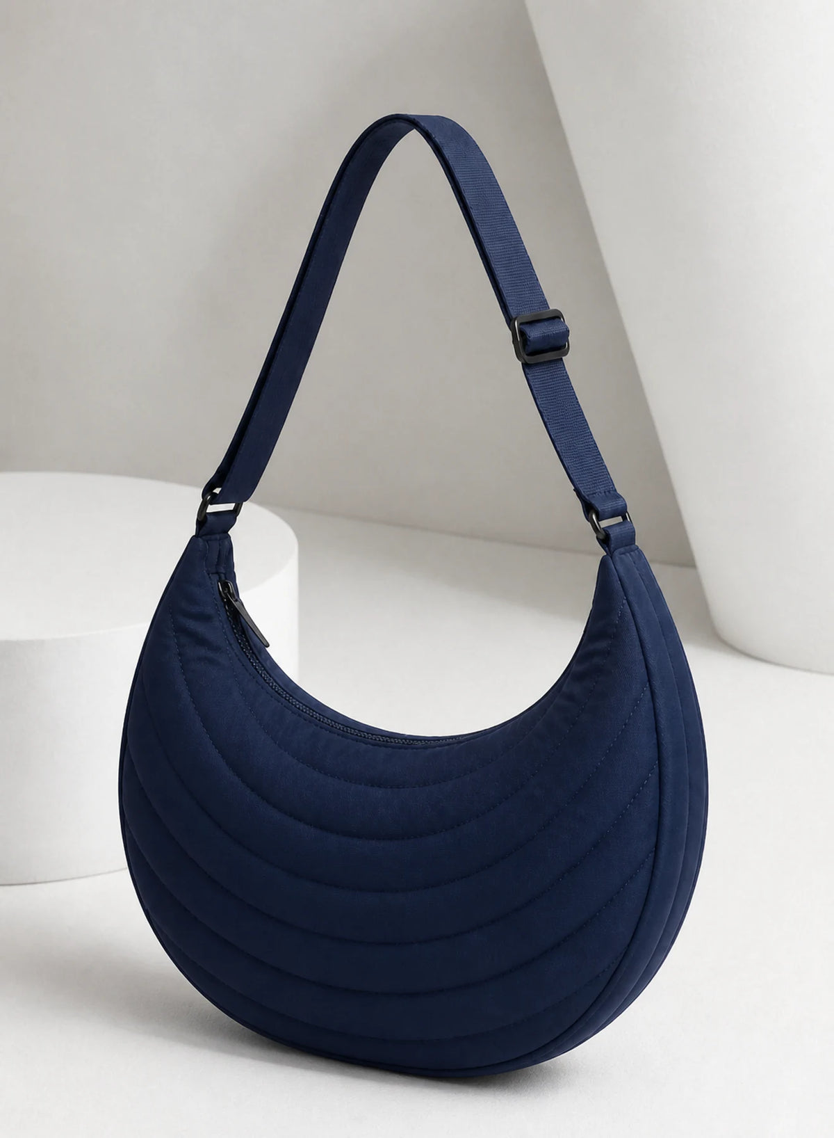 Crescent Shoulder Bag, shoulder bag shown in a complementary studio setting